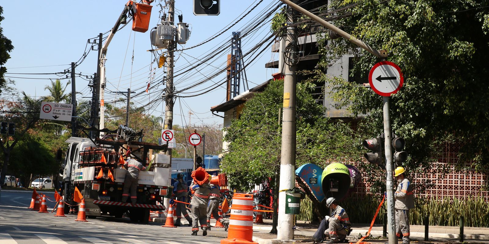 Funcionários da Enel fazem manutenção em poste de energia elétrica no bairro de Pinheiros.